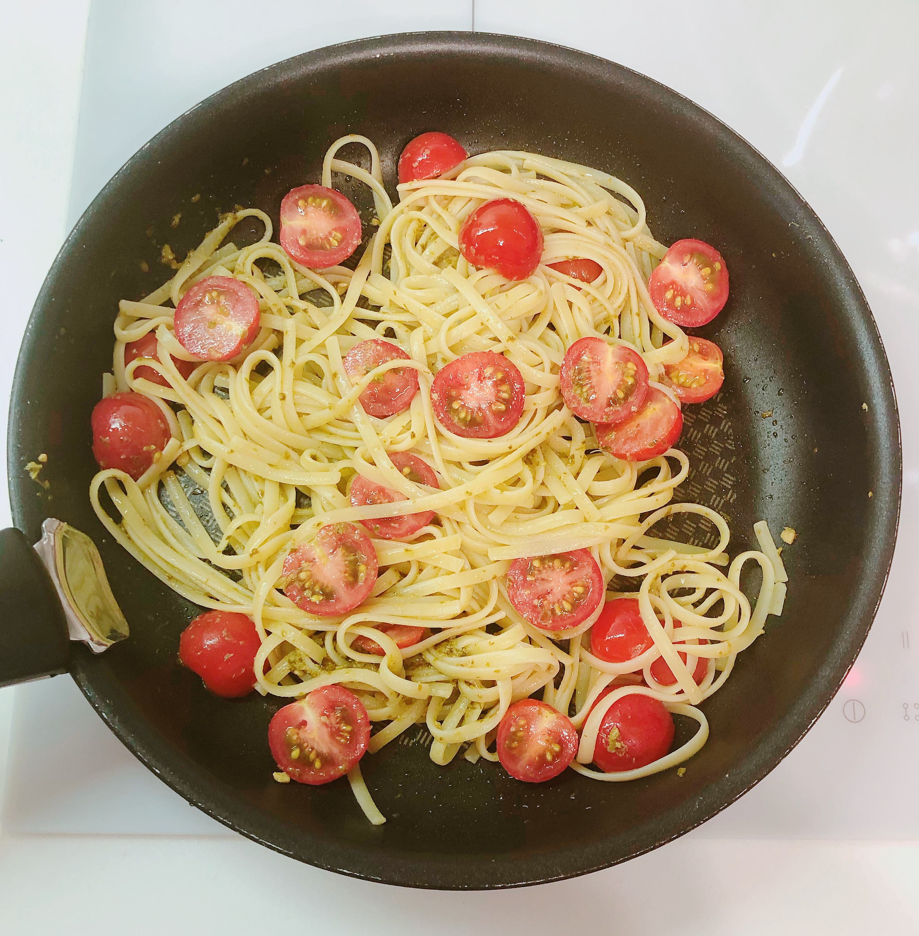 Fry mixed pasta with tomatoes and pesto sauce